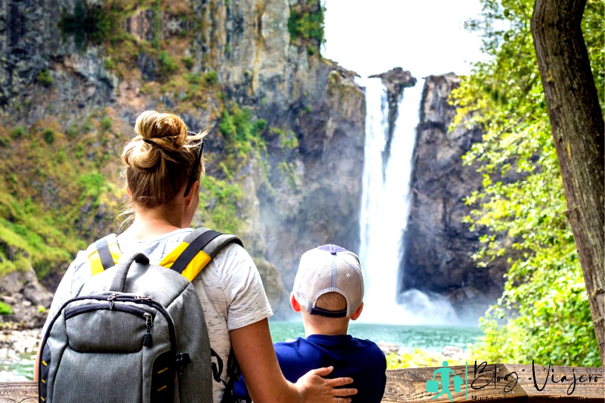 A family admiring a waterfall on flat level ground.