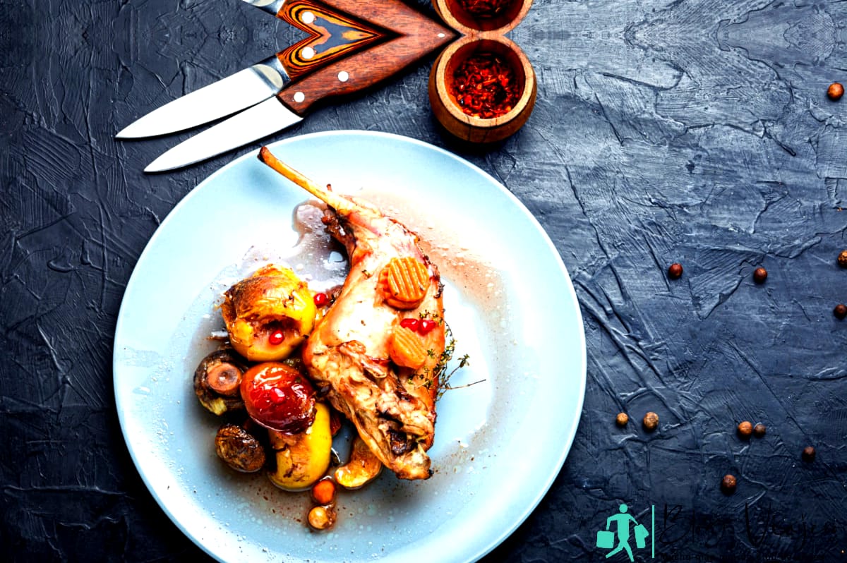 Pierna de conejo al horno con manzanas, zanahorias y champiñones.