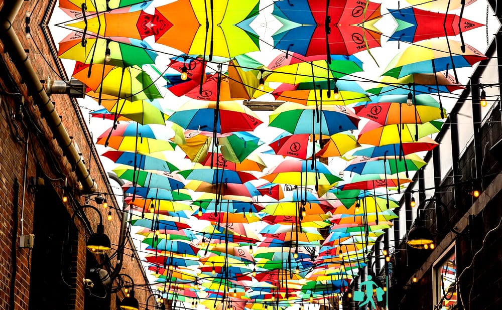 Paraguas de colores decoración de la calle en el estrecho callejón del distrito de arte RiNo en Denver, Colorado - Cosas que hacer en Denver, Colorado |  Atracciones turísticas de Denver