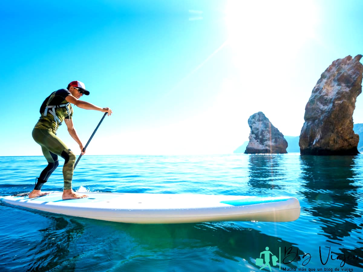 Hombre haciendo paddle surf en hermosas aguas