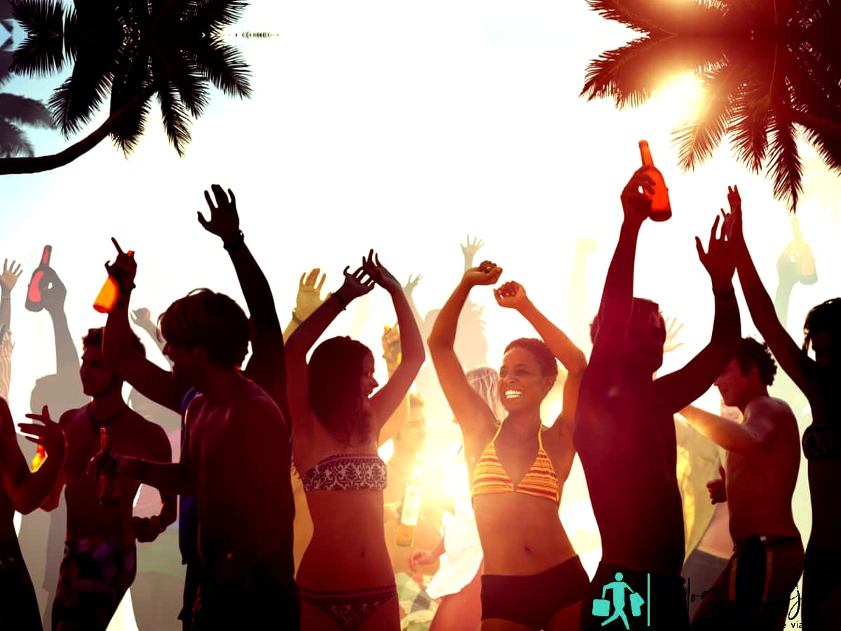 Gente celebrando en la playa durante la noche.