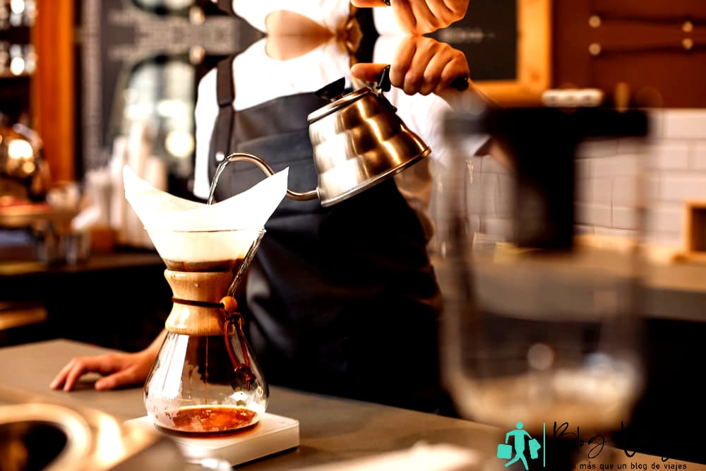 Lugares para comer en Payson, AZ: barista profesional que prepara café con una cafetera Chemex y un hervidor de goteo.  Formas alternativas de preparar café.  Concepto de cafetería.