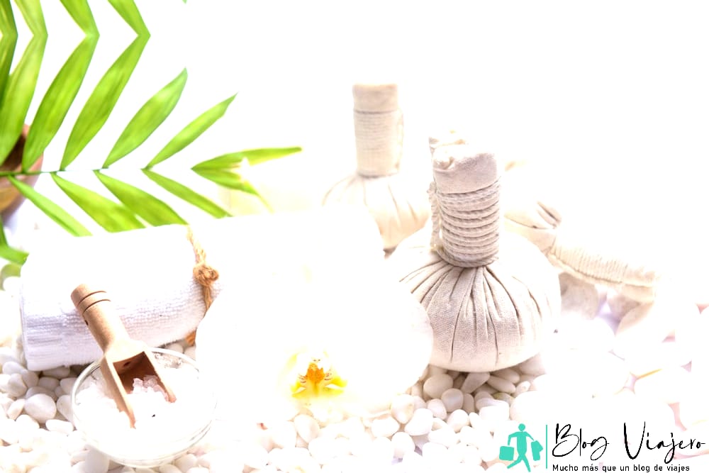 Ambiente de spa con orquídeas, botellas de aceite esencial, bola de hierbas y velas - Cosas que hacer en Destin no en el agua