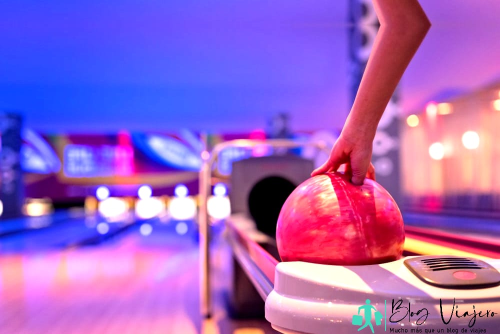 Cosas que hacer en Destin cuando llueve - Adolescente sosteniendo una bola de bolos, zapatos de bolos y una bola para jugar a los bolos.