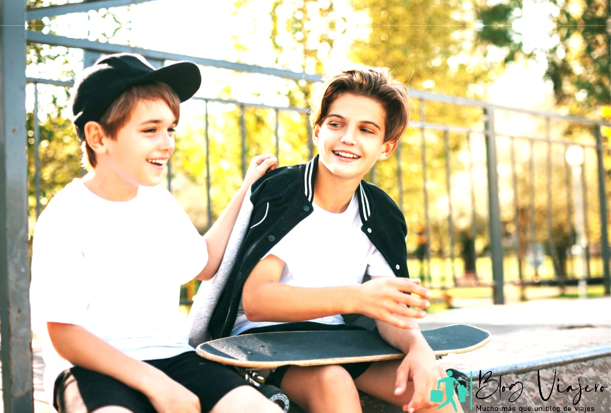 Los adolescentes se sientan en un skatepark, se relajan después de andar en patineta y conversan.