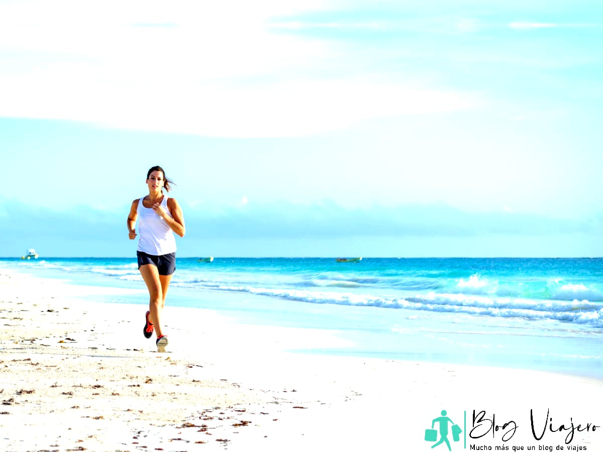 Mujer trotando en la playa durante las vacaciones en el Caribe