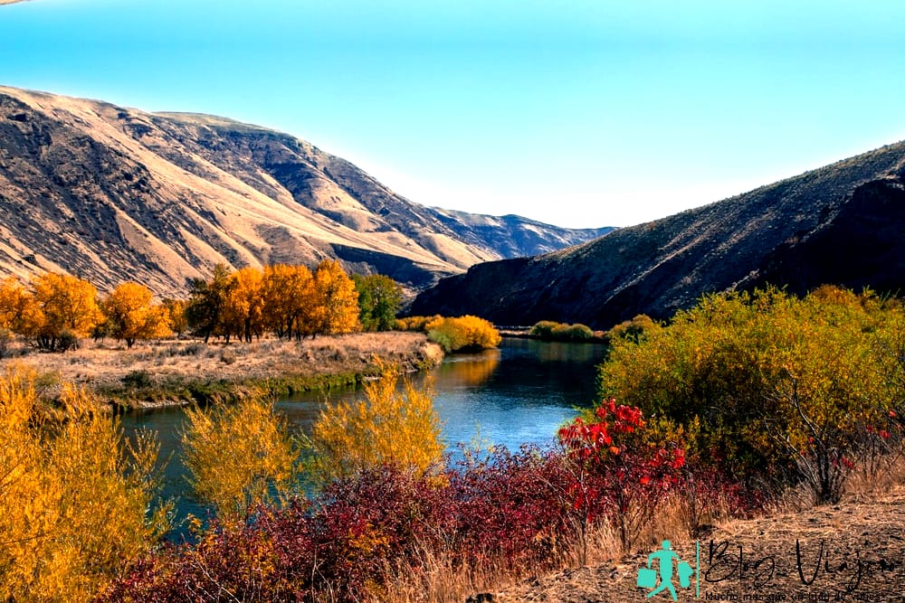 Cañón y río de Yakima en temporada de otoño. El cielo azul se refleja en el agua. Colores rojo, amarillo y naranja del follaje en ambas riberas