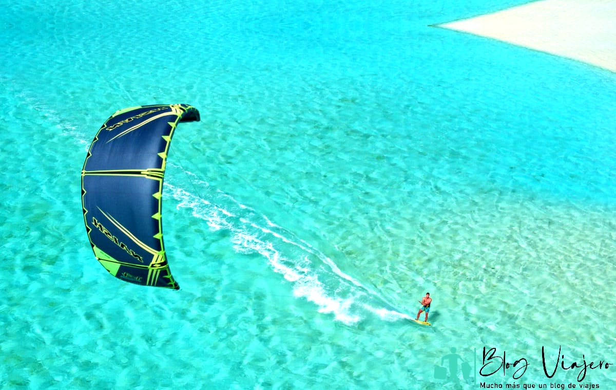 Joven kitesurf en el océano azul tropical